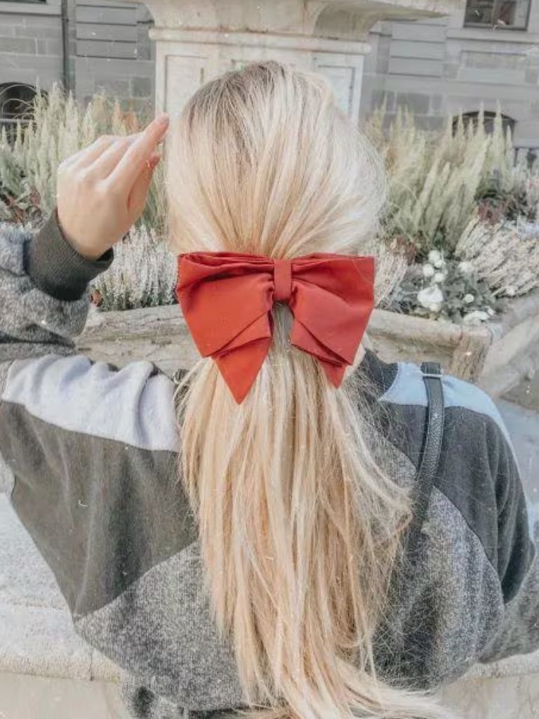 Blonde woman with a ponytail with a red bow