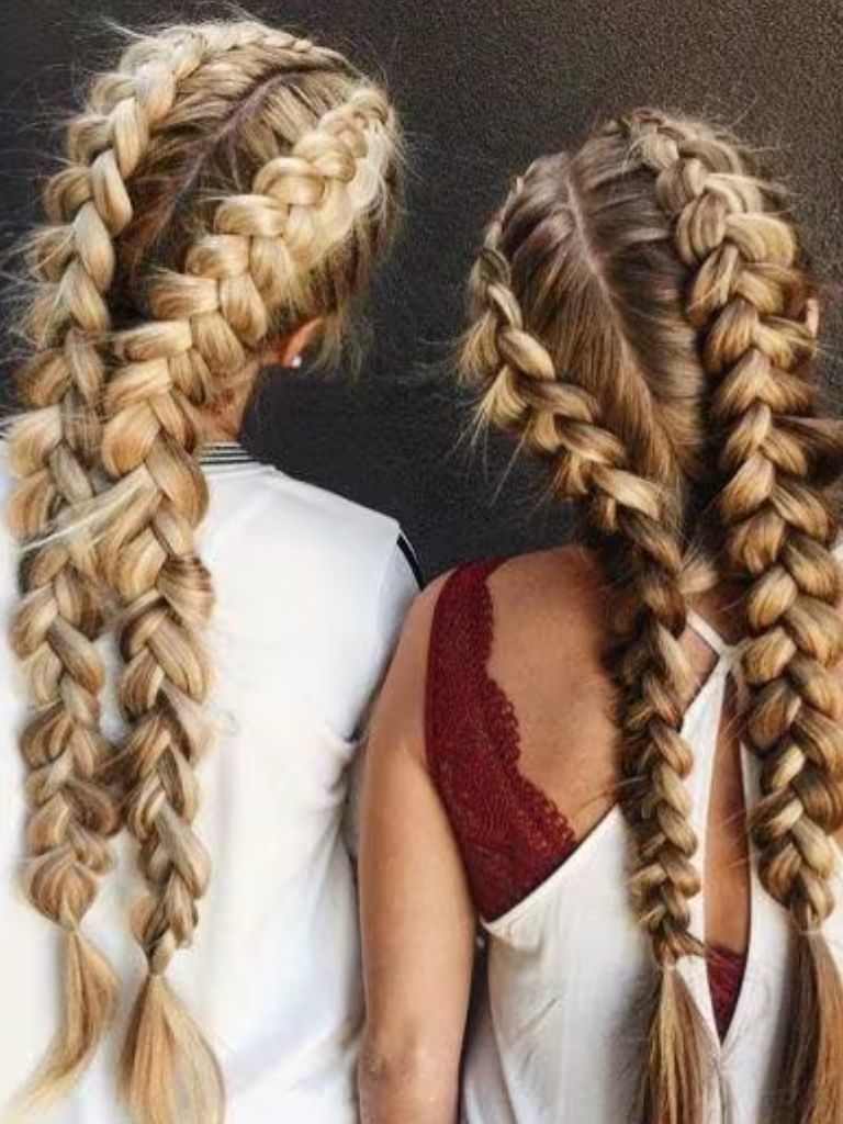 Two girls with long hair styled into braided pigtails