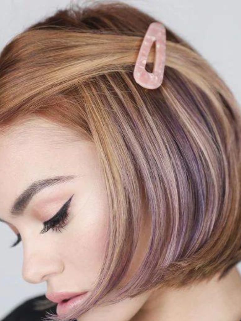 Woman with a purple highlighted bob with a pink snap clip