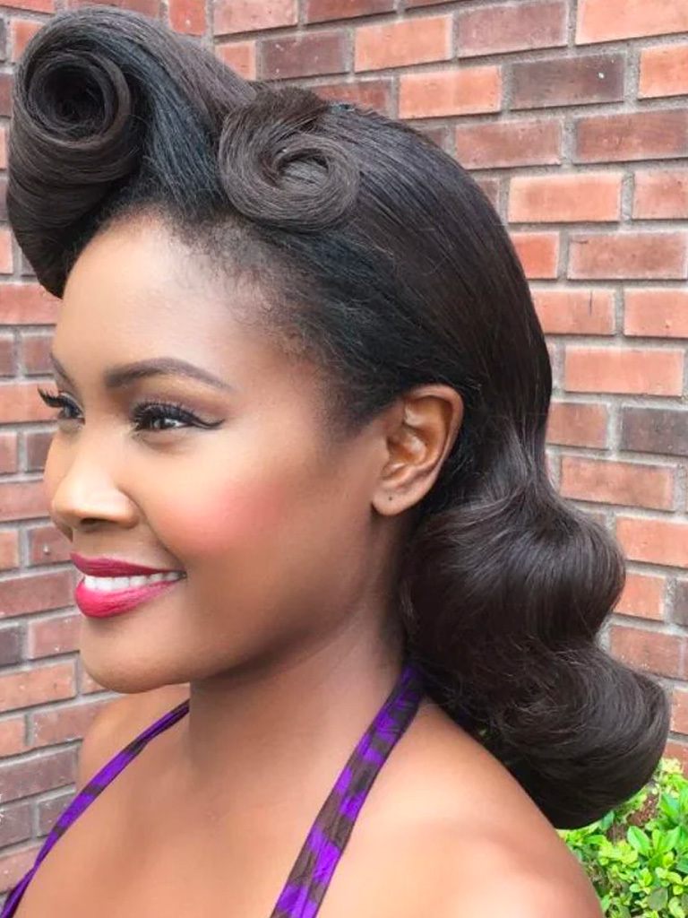 Woman with side victory curl on mid length hair wearing purple halterneck dress