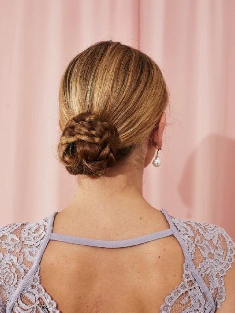 Blonde woman with a low braided chignon bun