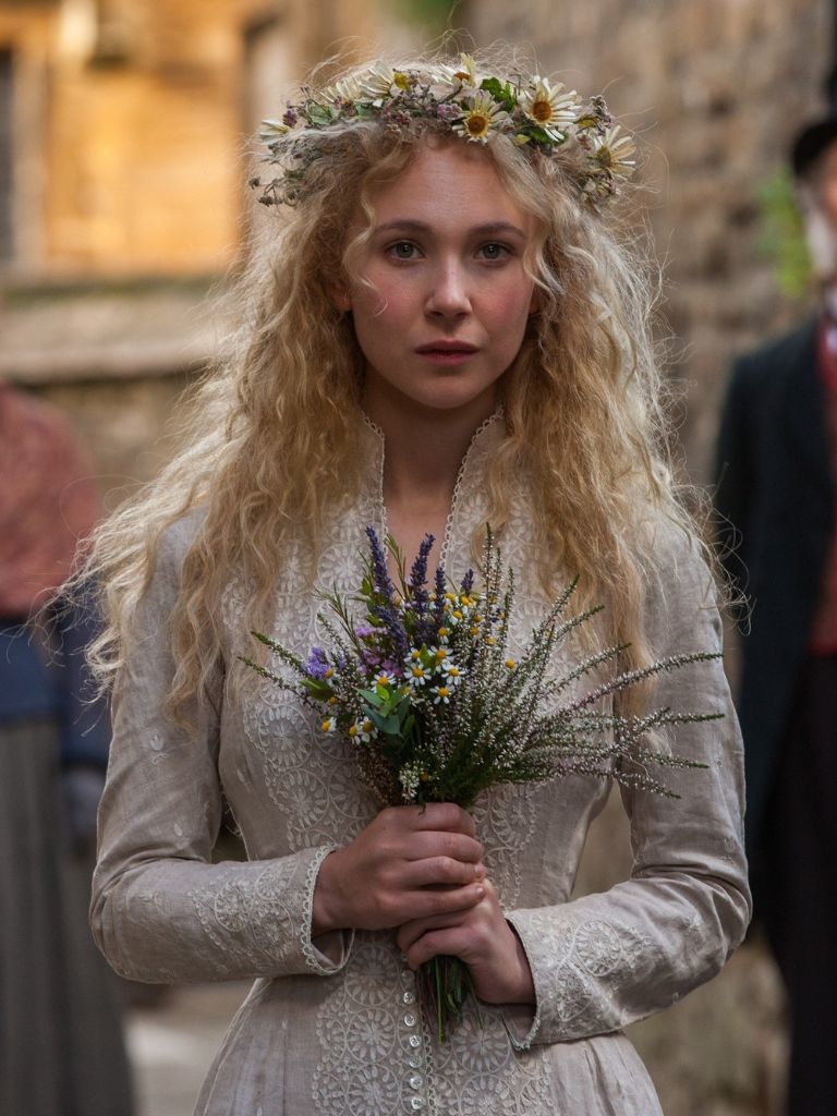 Victorian hairstyles: Close-up from Far From The Madding Crowd of Juno Temple with long wavy blonde hair and a flower crown