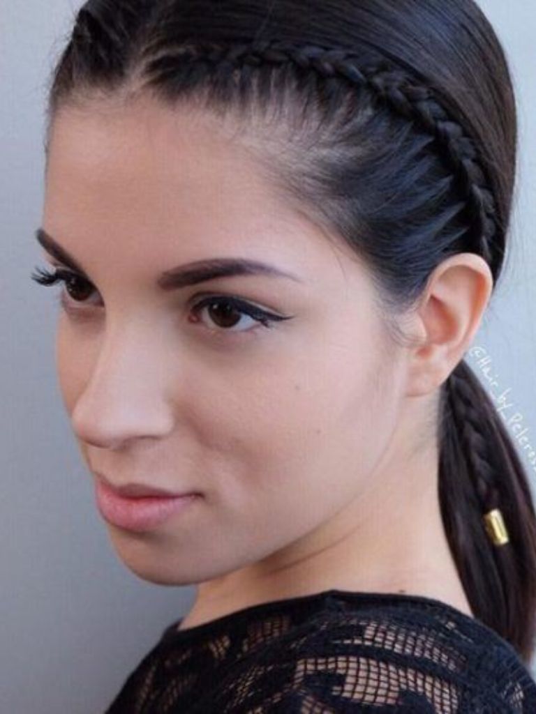 Easy braids for short hair: Woman with lob length dark hair tied in a ponytail with a cornrow accent braid