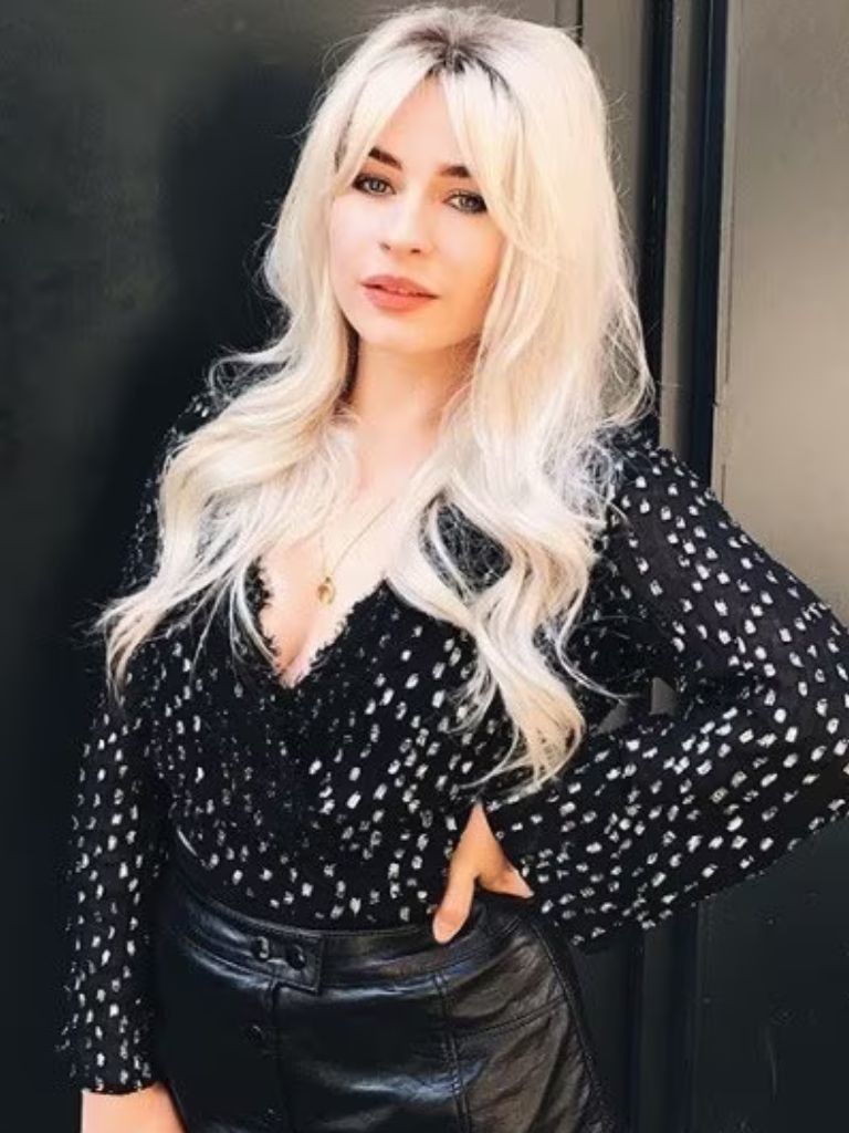 Club hairstyles: Woman with bleached blonde long curled hair in a Brigitte Bardot inspired lifted roots hairstyle