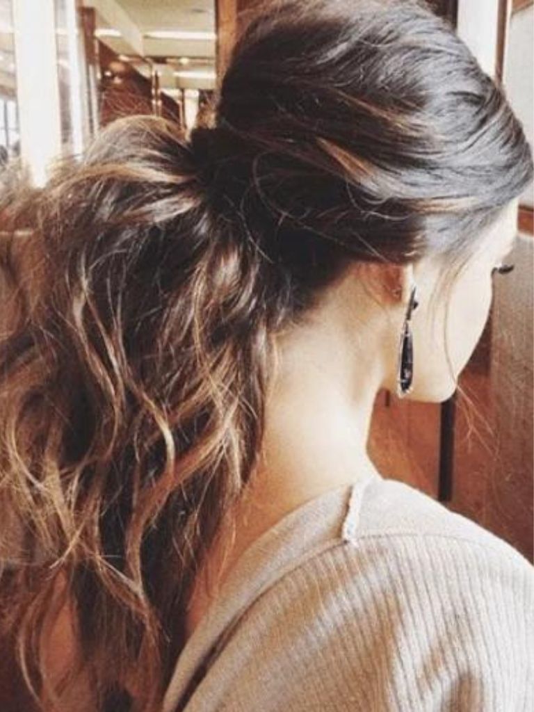 Club hairstyles: Back view of a voluminous wavy brunette ponytail