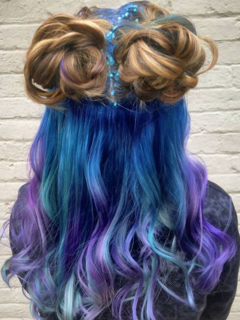 Girl with blonde space buns and glitter with blue hair.