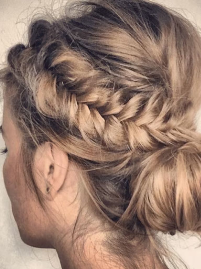 Club hairstyles: Back view of a woman's head with dirty blonde hair in braids and a loose bun