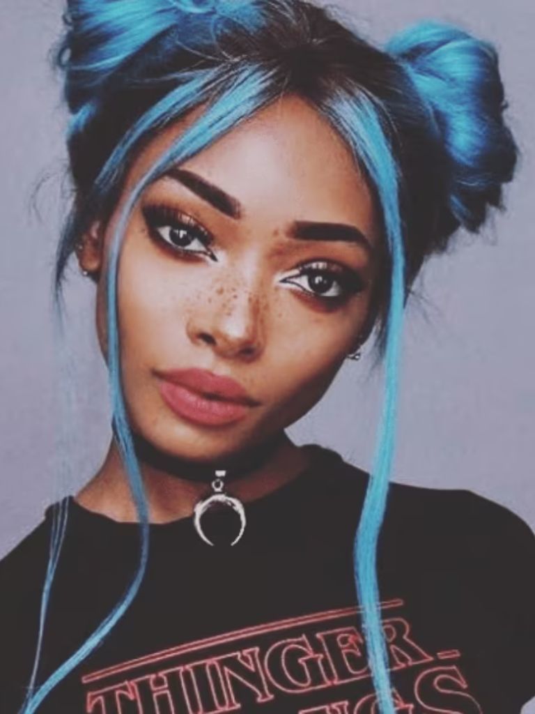 Club hairstyles: Front view of a woman with blue dyed hair in '90s space buns