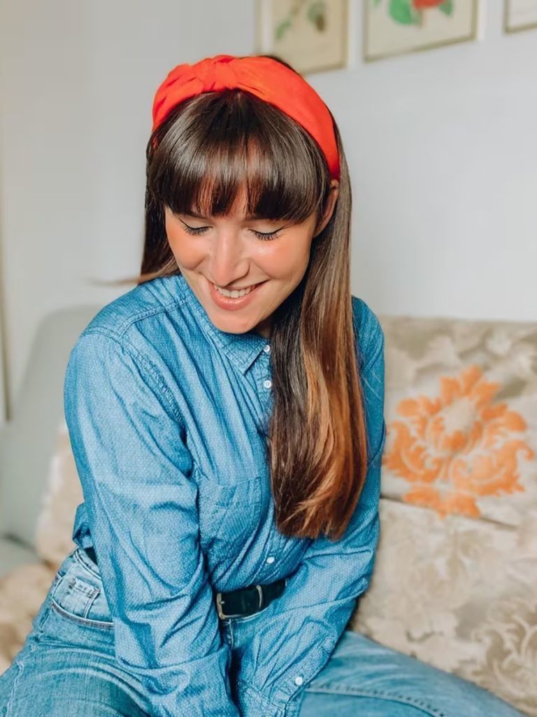 Woman with blow-dried bangs, wearing a red heaband