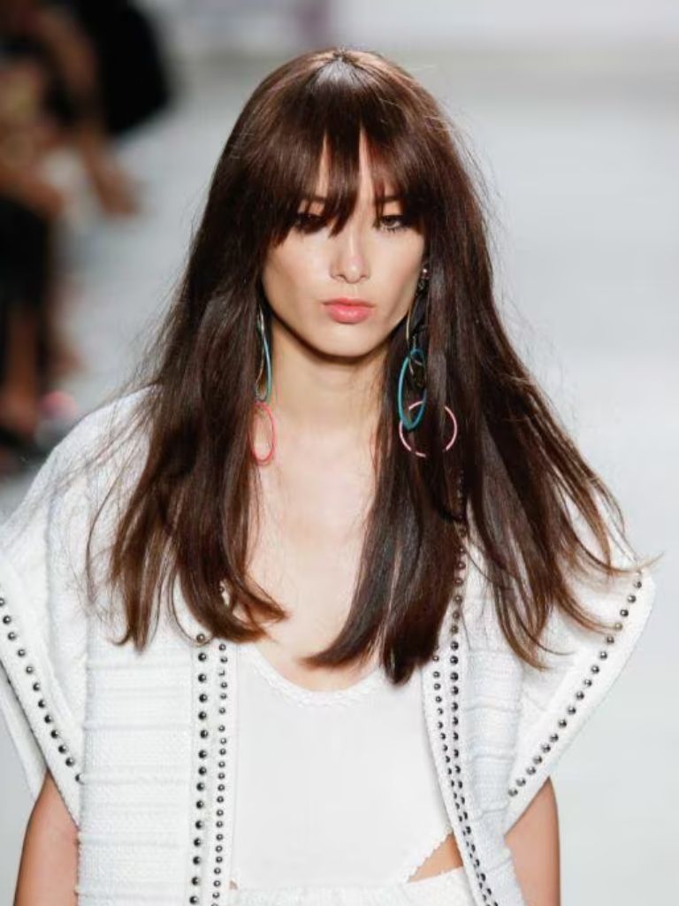 Woman on the runway with auburn long hair with wispy fringe haircut
