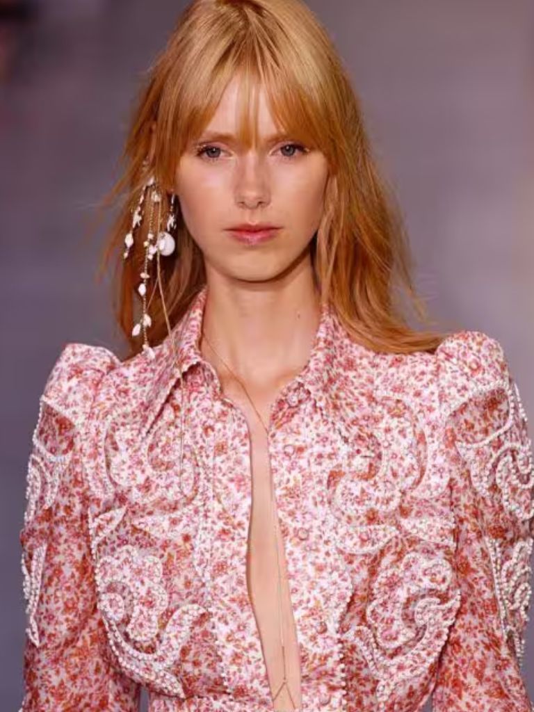Woman on the runway with strawberry blonde '70s-inspired wispy fringe style