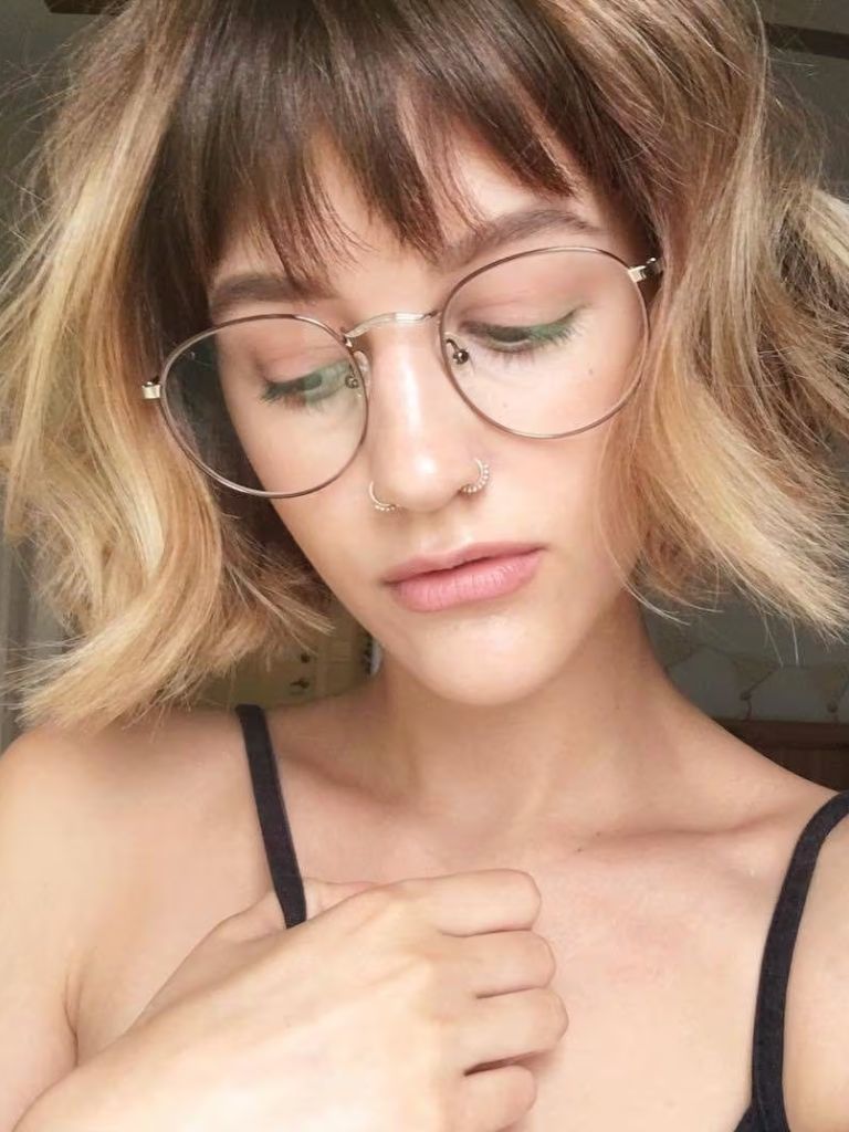 Woman with honey blonde short bob with dark brown bangs