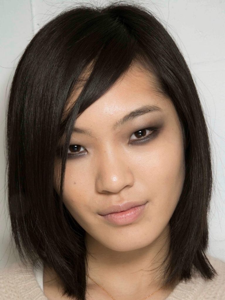 a close up look of an asian woman with medium straight black hair