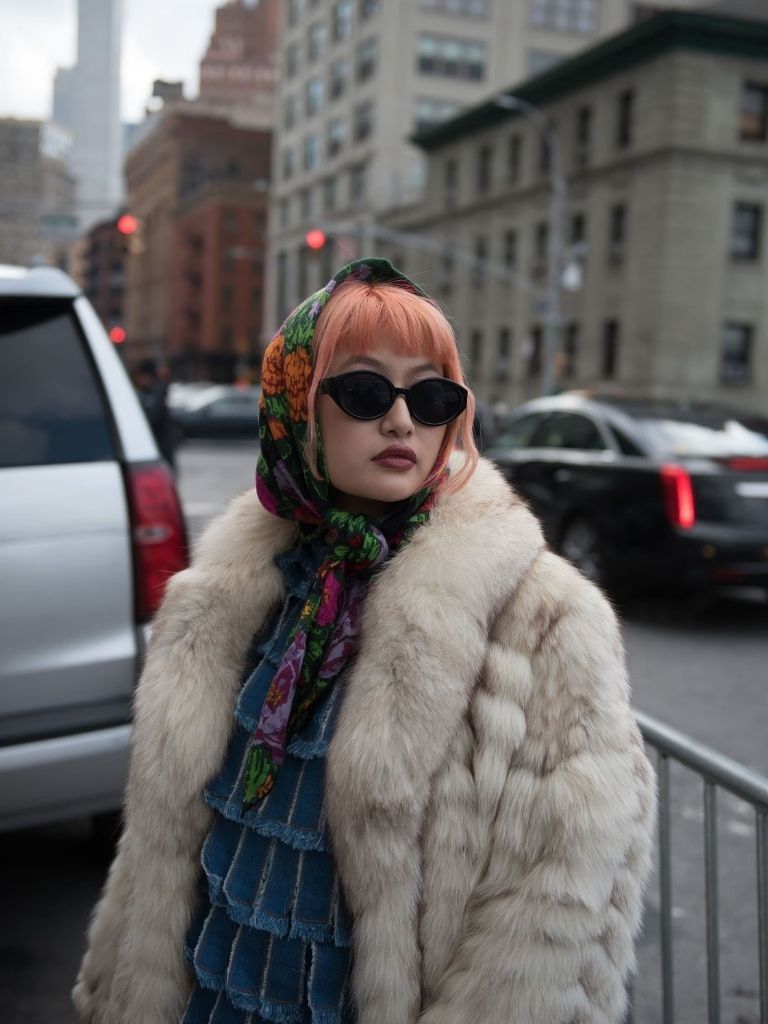 Woman with pink hair with bangs tied up in a patterned scarf