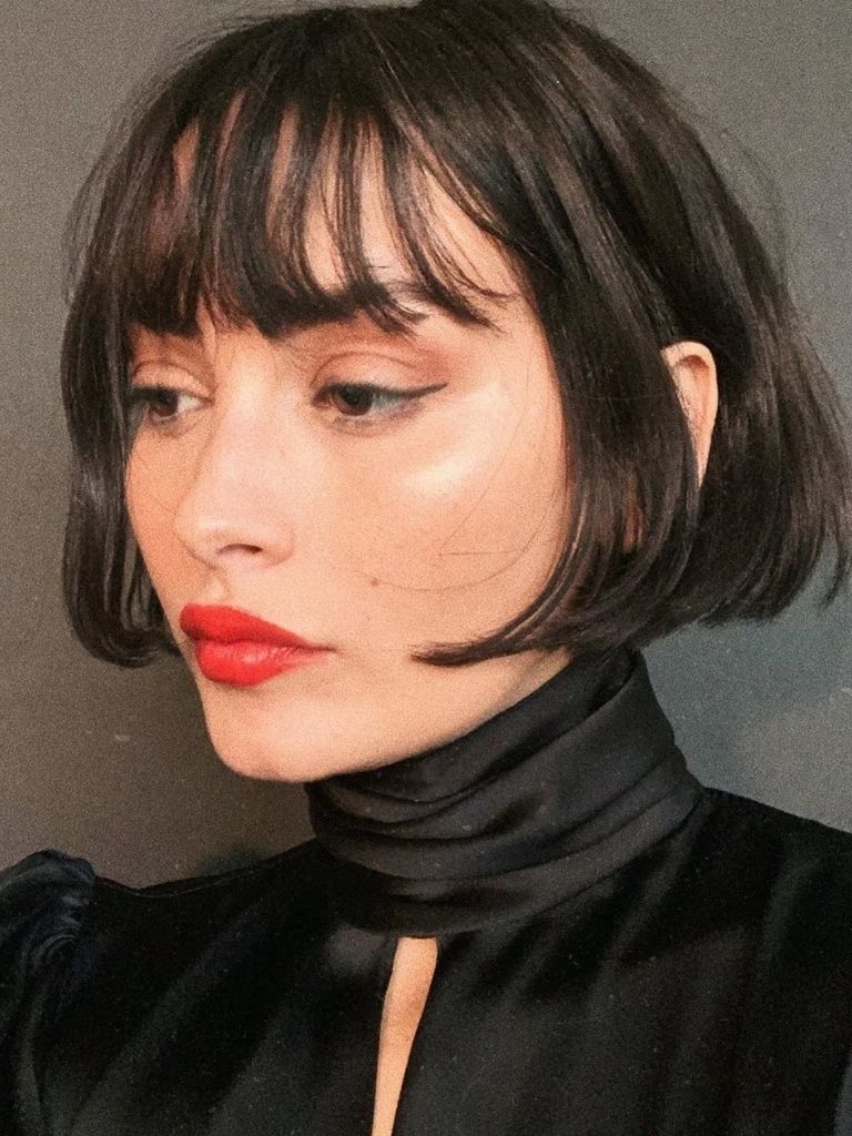 Model Taylor LaShae with a short cheek-length dark brown bob with bangs