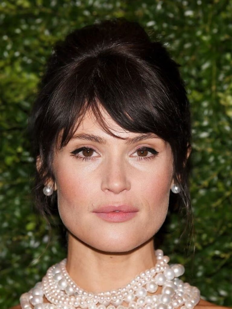 Gemma Arteton with brunette hair in an updo with split bangs
