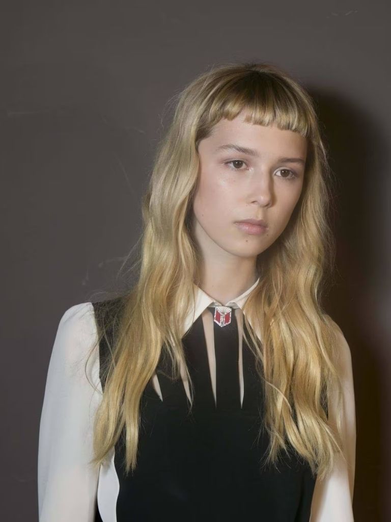 a female model with long blonde hair with bangs