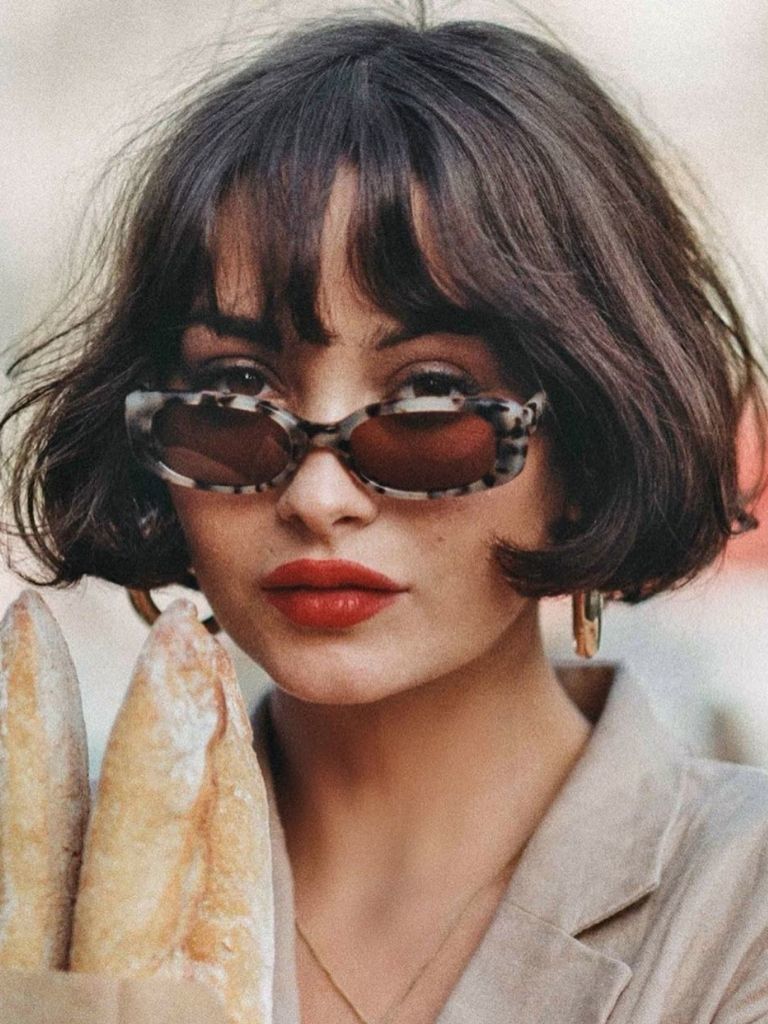 Woman with wispy bangs and French bob haircut