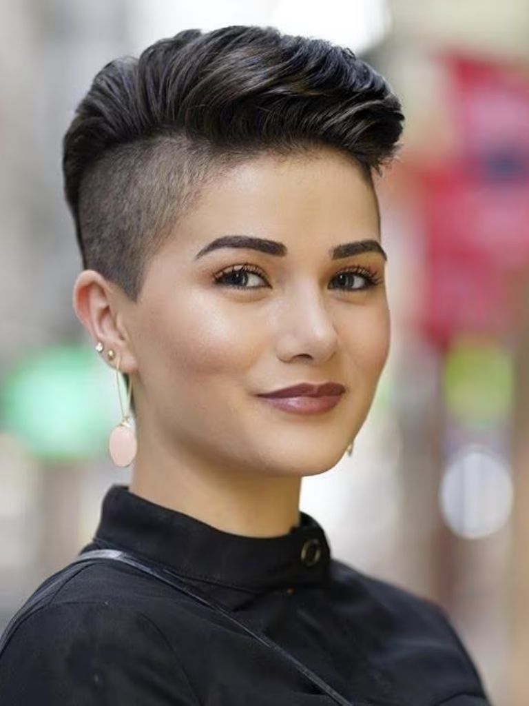 woman with a round face and swept back pixie with shaved side