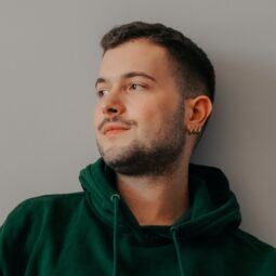Man with short hair in a green hoodie