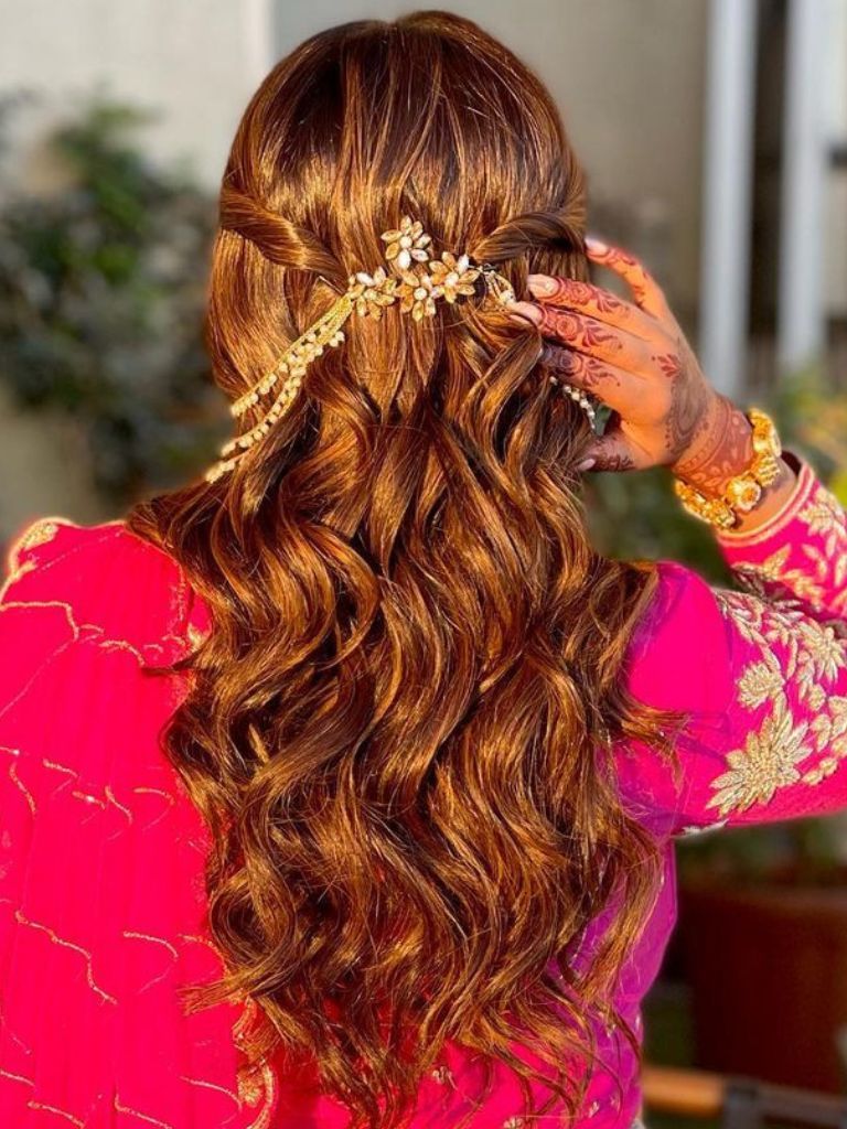 Woman with curly Indian bridal hair wearing henna.