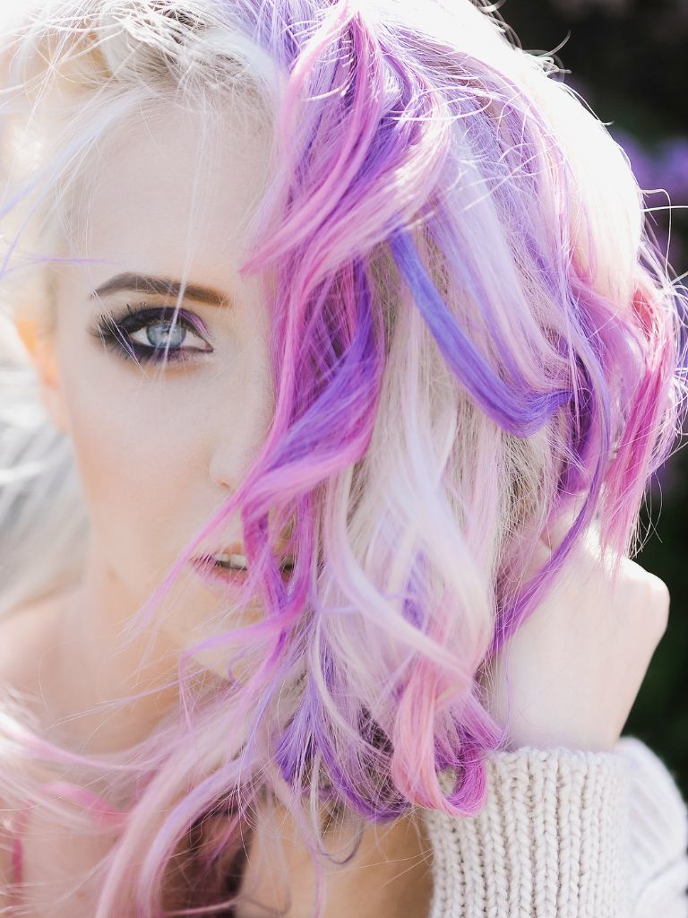 Woman with white blonde hair with purple and pink sections.