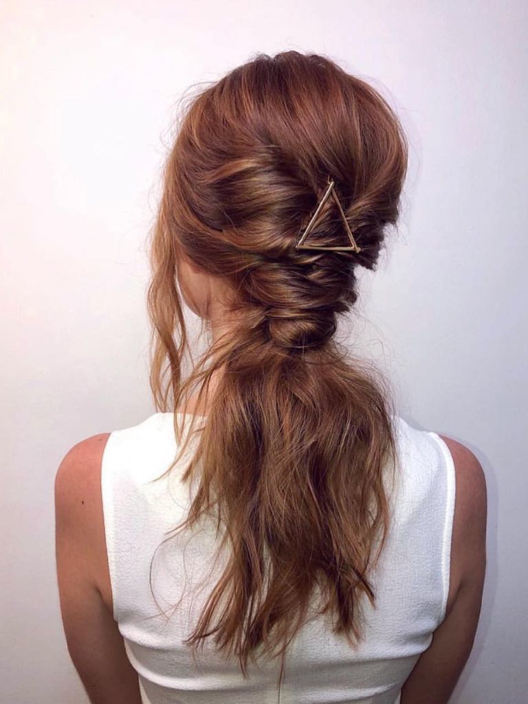 Woman with red faux braid with a triangle clip wearing a white top.