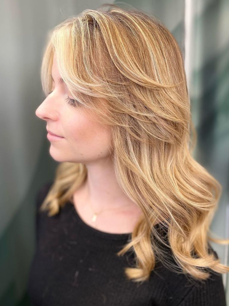 Woman with long thin blonde hair with curtain bangs.