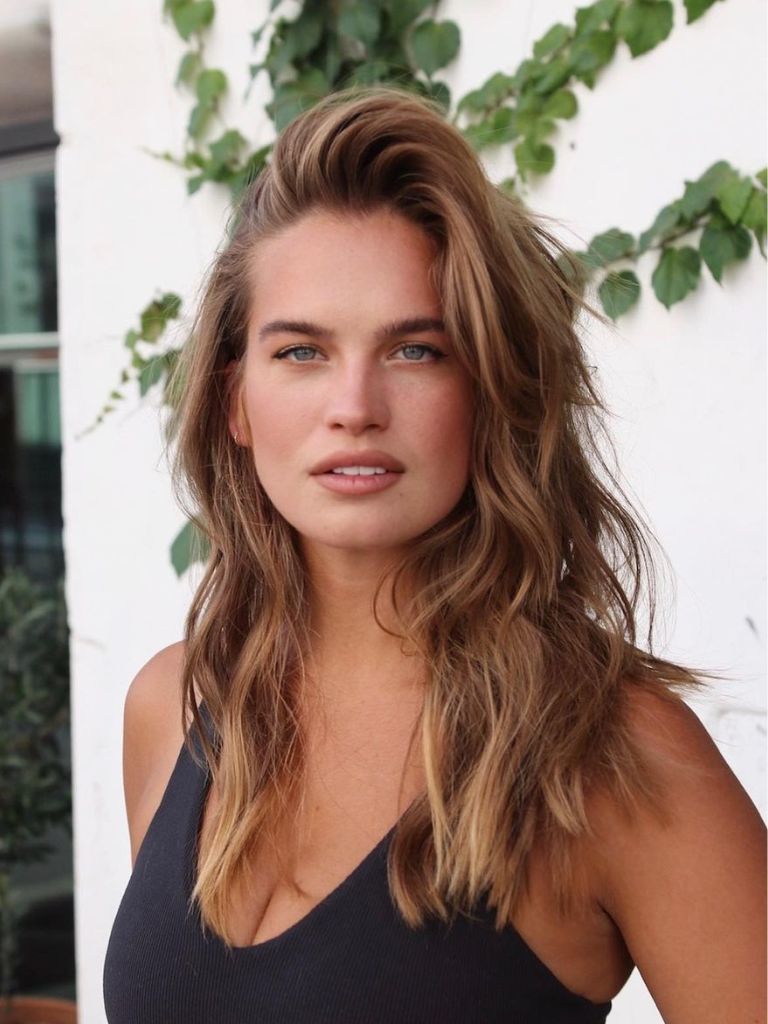 Woman with light brown hair and a deep side parting.