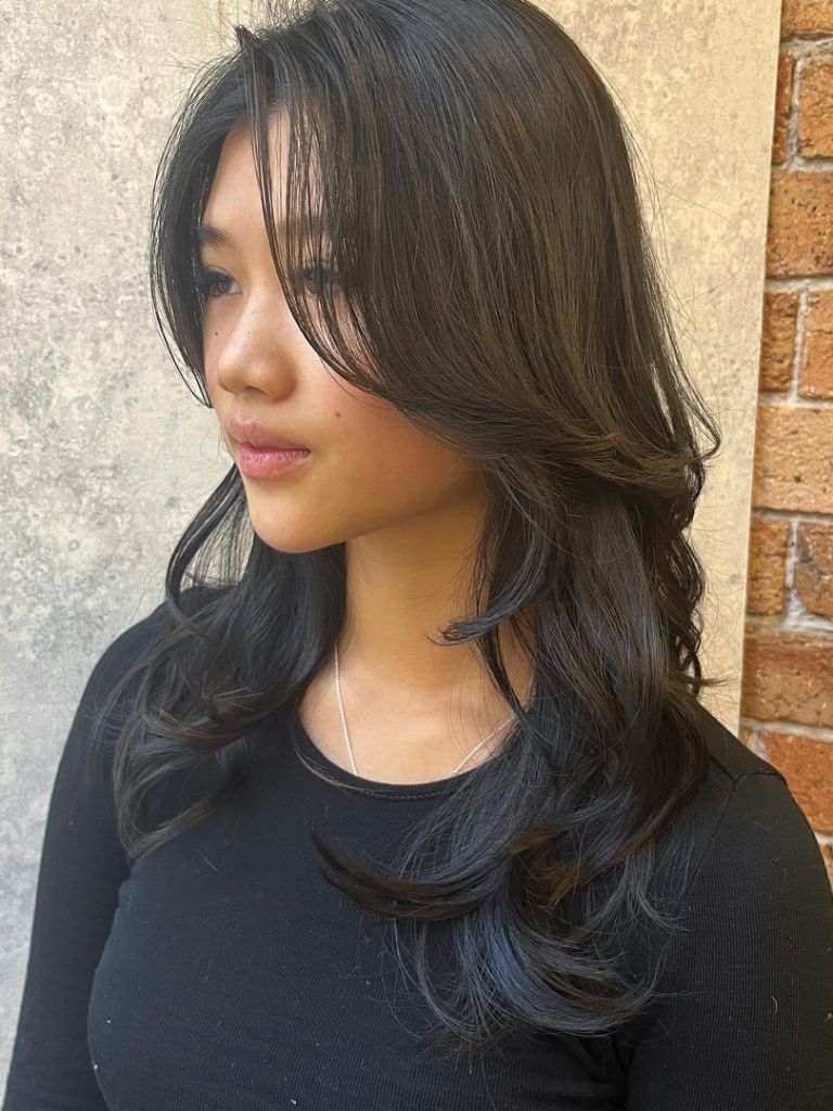 Woman with black hair with soft layers.