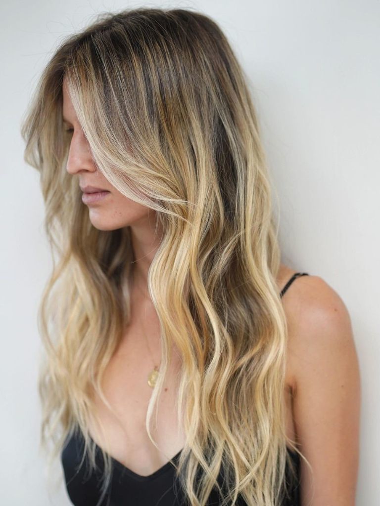 Hairstyles for long thin hair: Woman with long blonde hair with barely-there ghost layers.