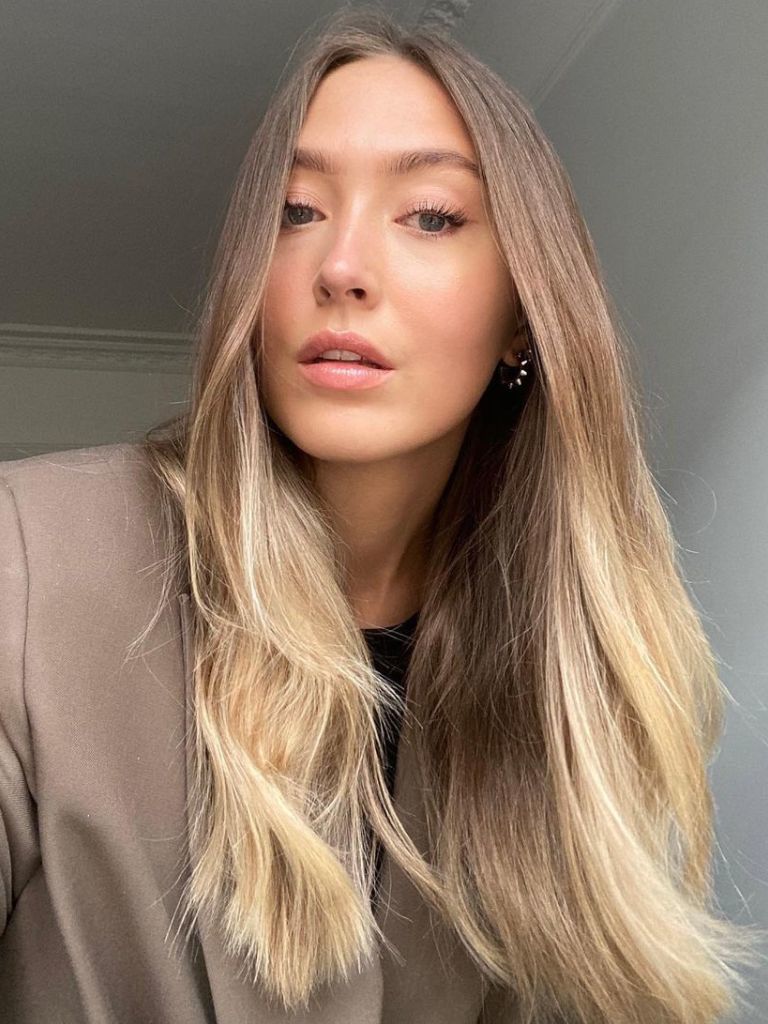 Woman with brown and blonde ombre hair with long layers.