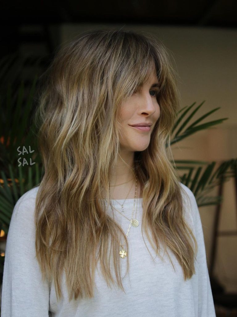 Hairstyles for long thin hair: Woman with light brown and blonde shag cut and bangs.