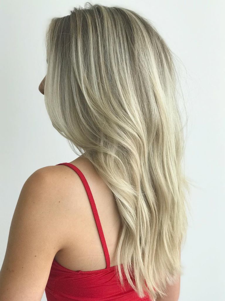 Woman with bright blonde hair and gradual layers.