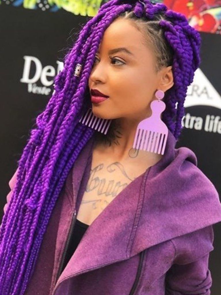 Woman with purple long box braids with temple shaved undercut with hair-comb-earrings.