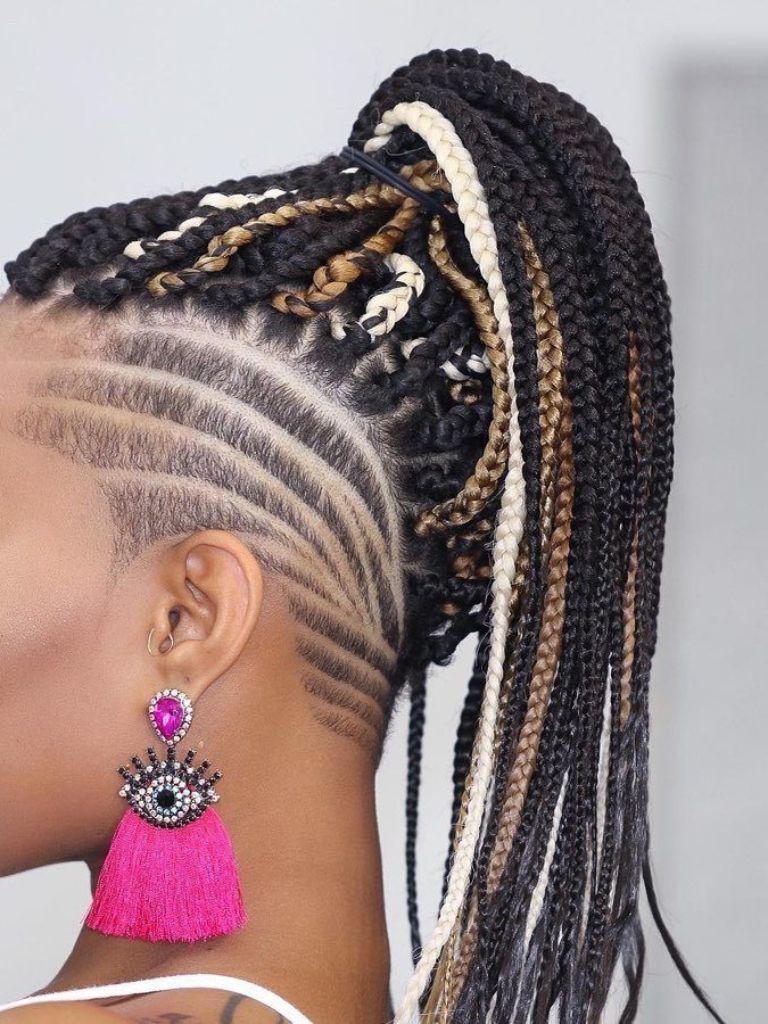 Woman with dark box braids styled into a high ponytail with shaved.