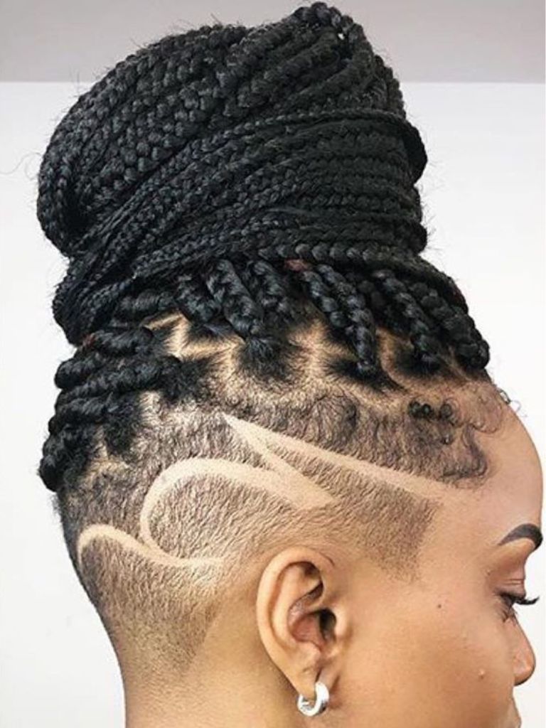 Woman with box braids updo with patterned shaved undercut.