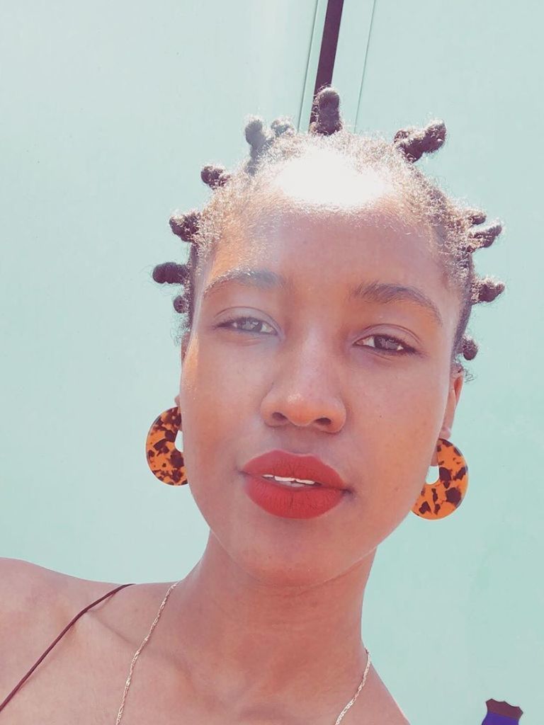 Woman with small Bantu knot hairstyle.