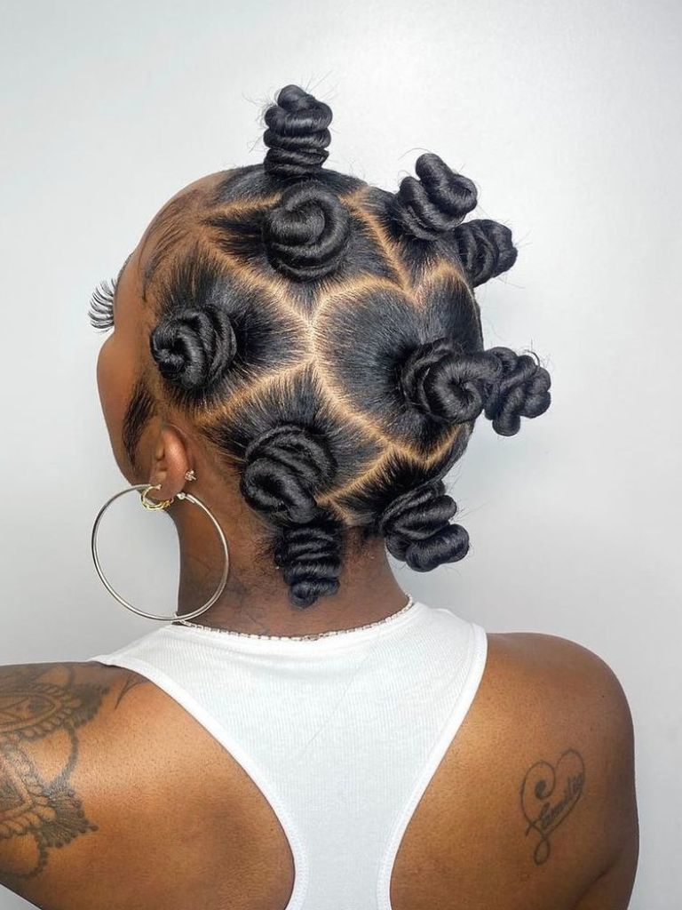 Woman wearing Bantu knot hairstyles with locs.