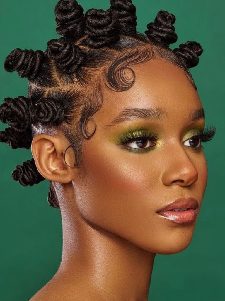 Woman with pretty coiled Bantu knots with curly hair edges framing the style.
