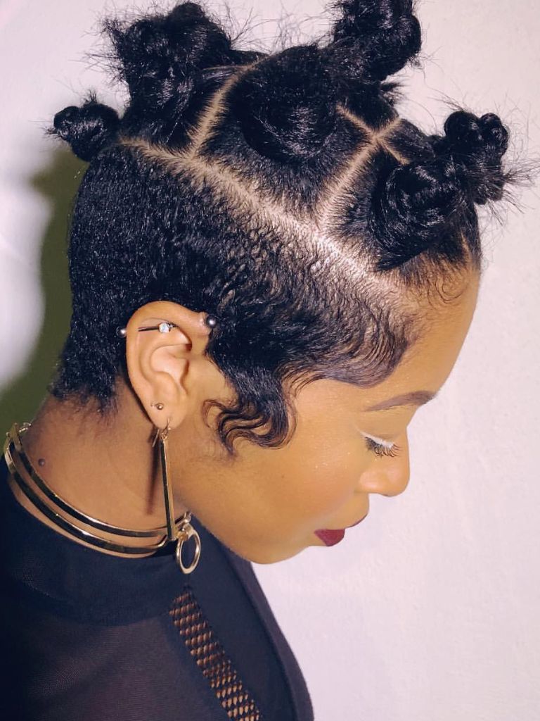 Woman with Bantu knot hairstyle with playful partings.