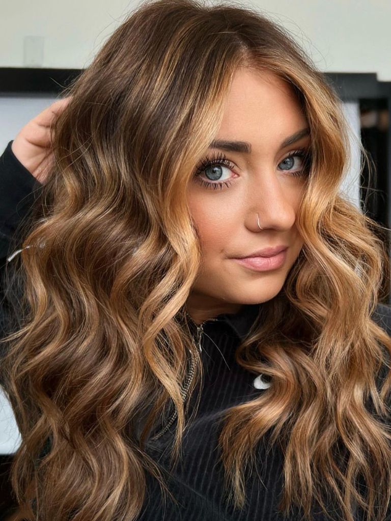 Woman with honey caramel balayage and curly hair.