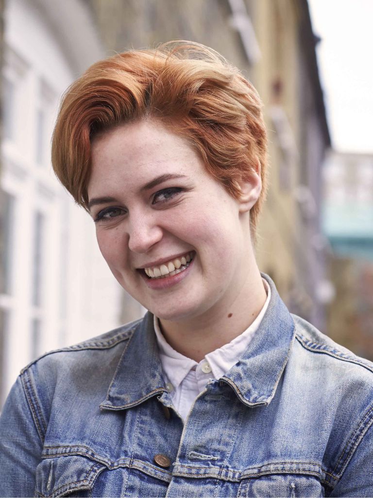 Hairstyles for round faces: Woman with copper tapered pixie cut.