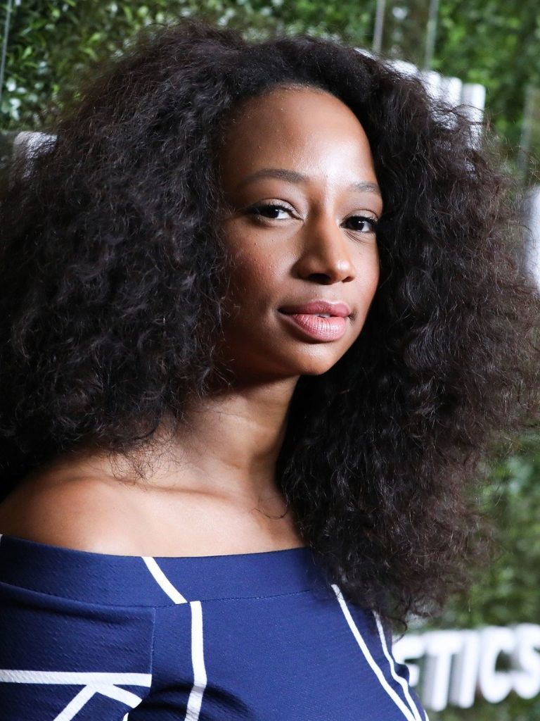Hairstyle ideas for a round face: Monique Coleman with big curly hair at Fabletics event.