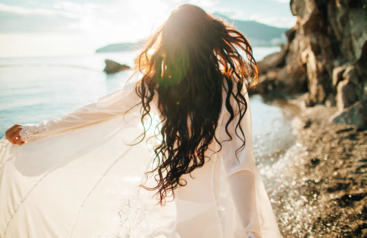proteger el pelo del sol mujer corriendo en la playa