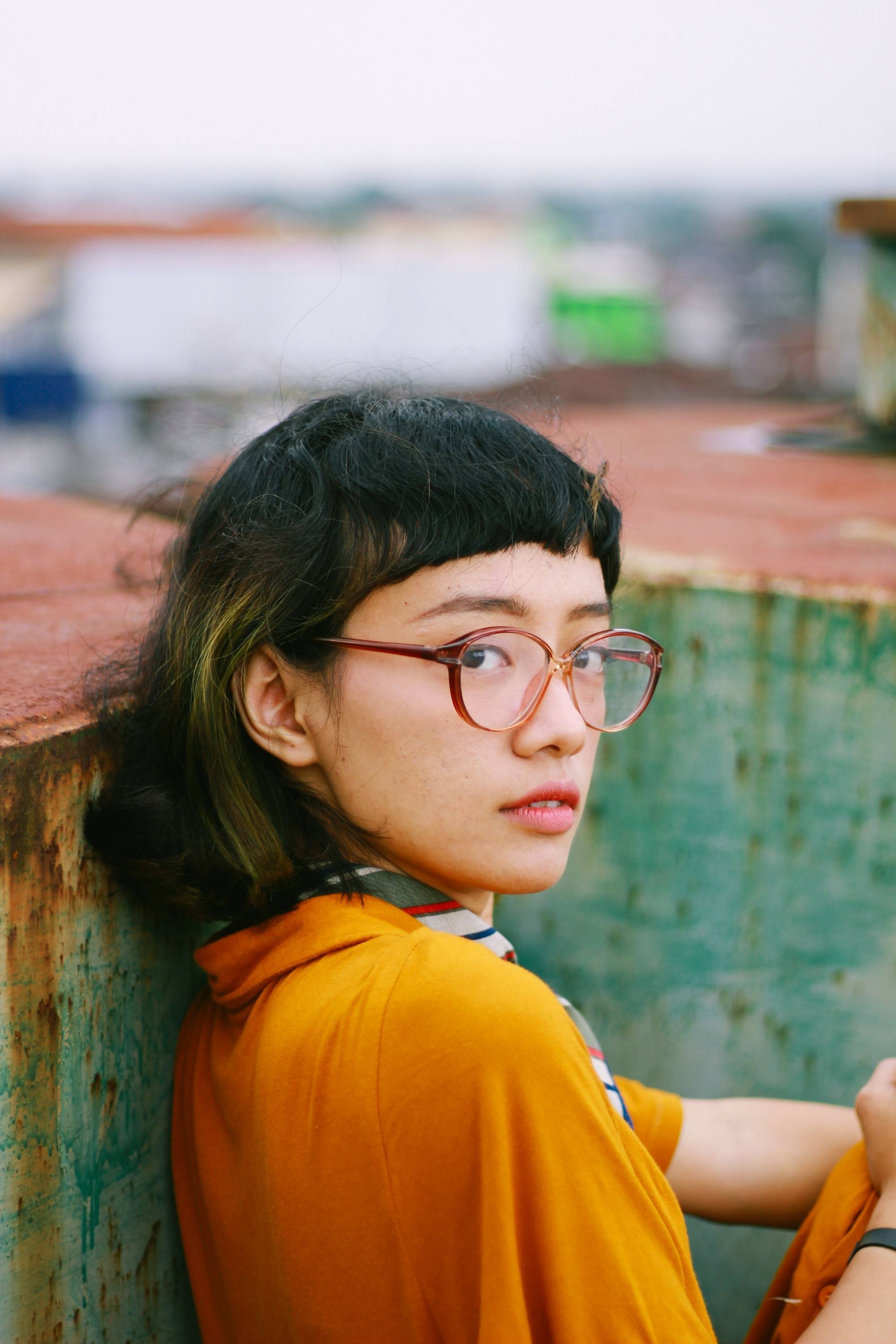 Asian woman with short hair with baby bangs wearing eyeglasses