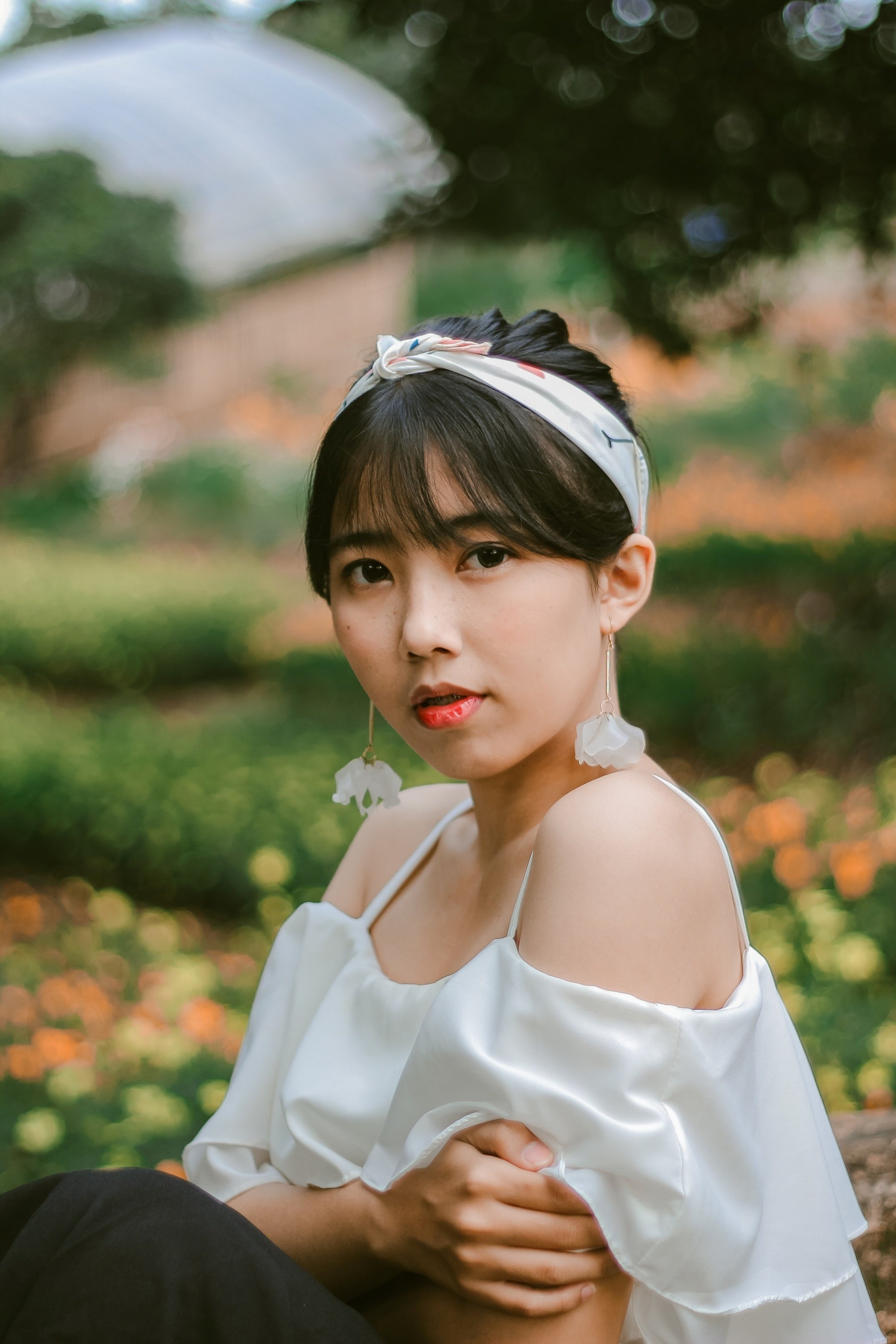 Asian woman with an updo hairstyle with bangs wearing a headband