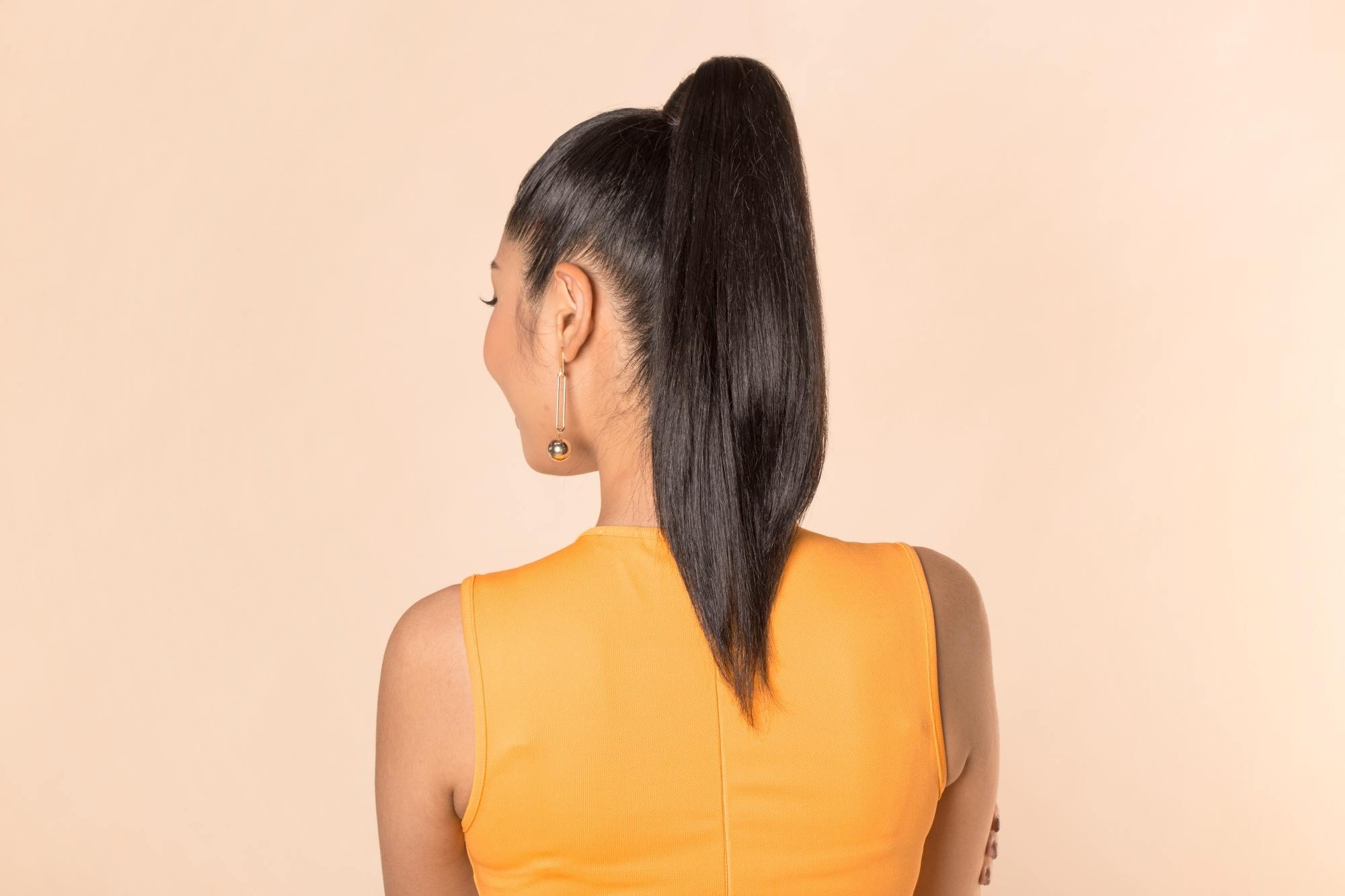Back shot of an Asian woman with long straight hair in a high ponytail