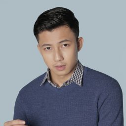 easy hairstyles for men: guy is wearing a long-sleeved shirt and his holding the cuff of his shirt