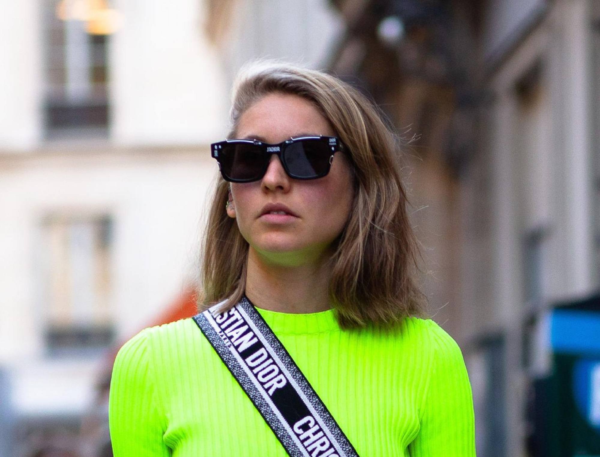 Hair color for morena skin: Closeup shot of a woman with dirty blonde lob wearing a neon green shirt outdoors